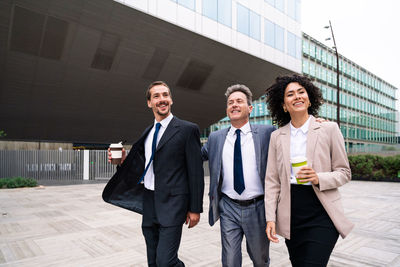 Portrait of businessman standing against building