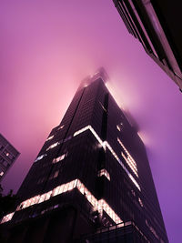 Low angle view of modern building against sky during sunset