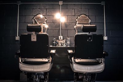 Empty chairs at illuminated barber shop