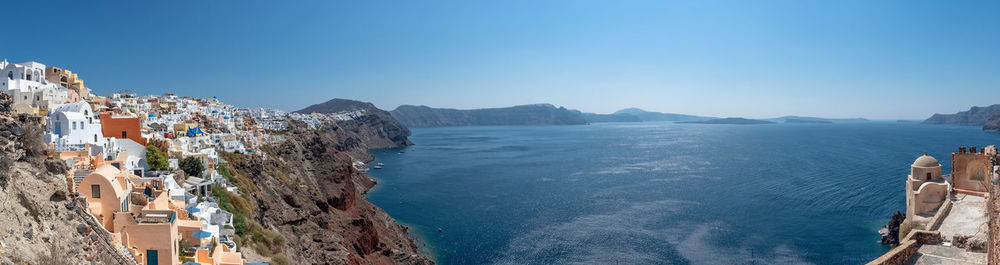 Panoramic view of sea and buildings against clear blue sky