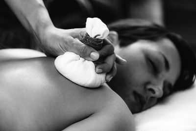 Hands of an ayurveda massage therapist pressing herbal bolus bags