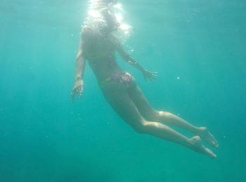 Full length of young woman swimming in sea