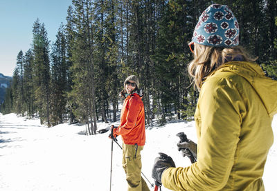 Two young women cross-country ski on mt. hood on a sunny day.