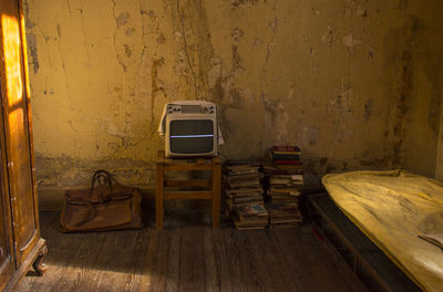 Old-fashioned television and books in abandoned room