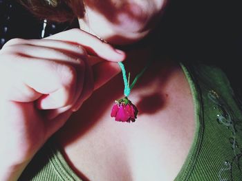 Close-up of young woman wearing rose in neck