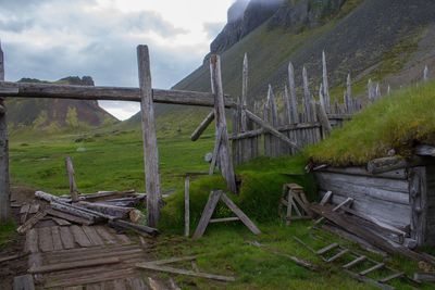 Wooden posts on landscape against sky