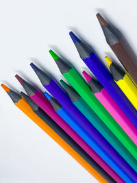 High angle view of colored pencils on white background