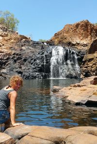 Full length of waterfall on rocks against mountain