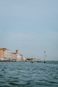 Scenic view of sea by buildings against sky