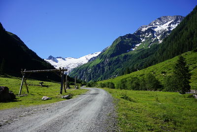 Road amidst green landscape against clear sky