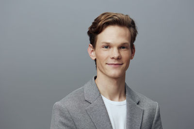 Portrait of young man against gray background