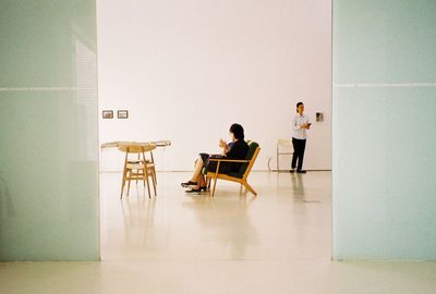 People sitting on table against wall