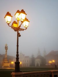 Low angle view of illuminated street light against sky