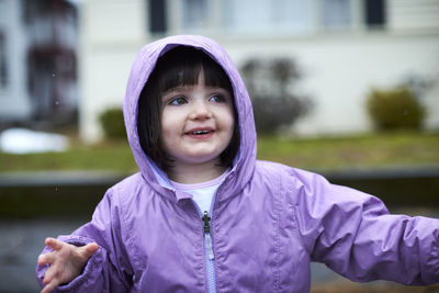 A portrait of a little girl outdoors on a rainy day.