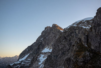 Low angle view of snowcapped mountains against clear sky