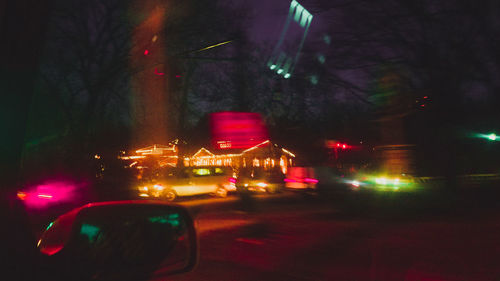 Illuminated cars on road against sky at night