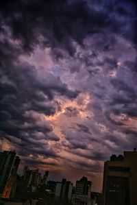 Cityscape against cloudy sky at sunset