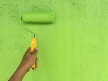 Close-up of hand painting wall