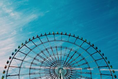 Low angle view of ferris wheel against blue sky