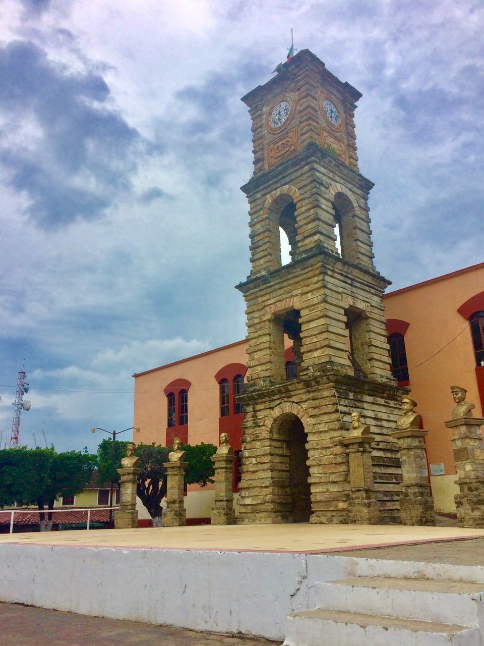 LOW ANGLE VIEW OF CLOCK TOWER AMIDST BUILDINGS AGAINST SKY