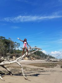 Woman standing on beach against sky