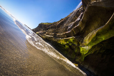 Low angle view of waterfall against sky