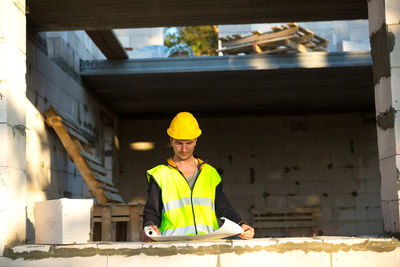 Constructor worker looking at plan on construction site