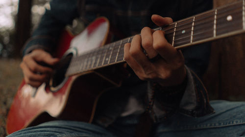 Midsection of man playing guitar