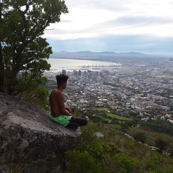 Man on riverbank against sky