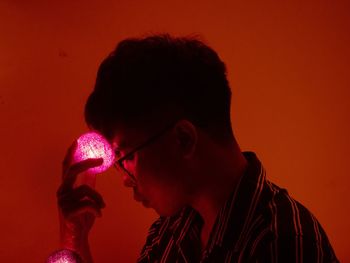 Close-up of young man against red background