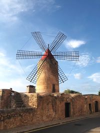 Low angle view of traditional windmill against sky