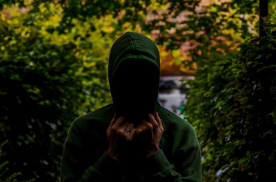 Rear view of man standing against trees