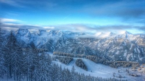 Scenic view of snow covered landscape against blue sky