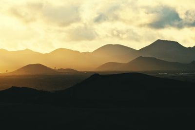 Scenic view of mountains against sky at sunset