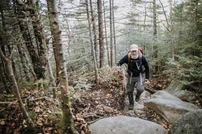 A male retirement age hiker walks on the appalachian trail in maine