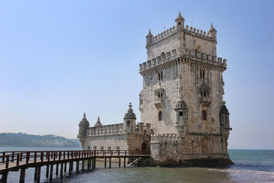 Building by sea against clear sky