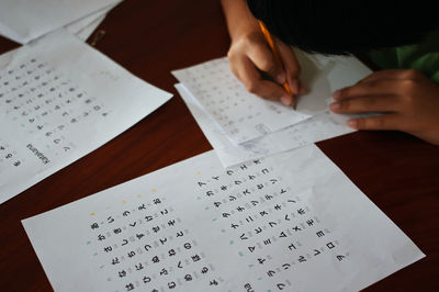 Cropped hands of boy writing in paper
