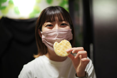 Portrait of woman holding sembei.