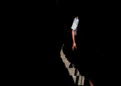 Cropped image of man walking on steps in building