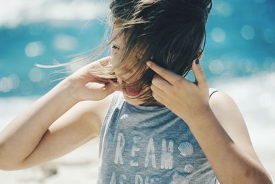 Cheerful girl with tousled hair at beach