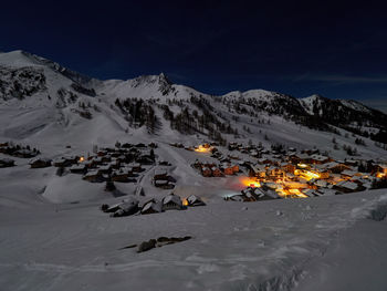 Aerial view of snowcapped mountains against sky at night