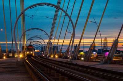 Cable car against sky during sunset at railway bridge in city