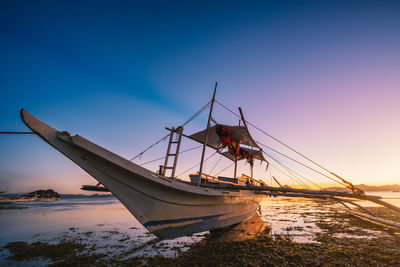 Fishing boat on beach against clear sky