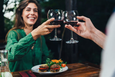 Young woman holding drink on table at restaurant