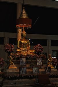 Statue against illuminated building