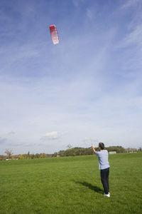 Full length of man playing with umbrella on field