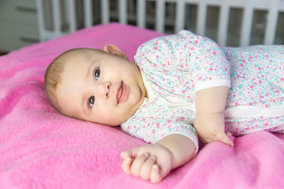 Portrait of cute baby boy lying on bed at home