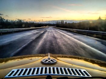 Car on road against sky during sunset