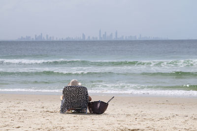 Rear view of couple sitting on beach