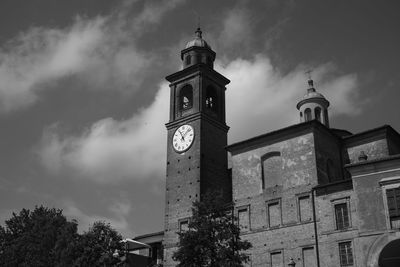 Low angle view of clock tower amidst buildings against sky